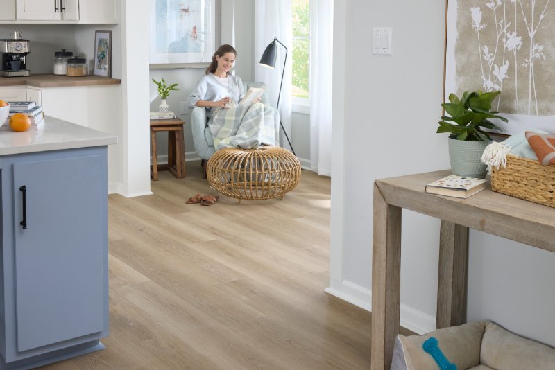 Woman reading in a cozy home with Pergo Elements flooring