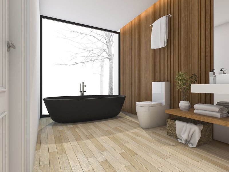 black bathtub with brown hardwood flooring by Carolina Flooring and Interiors in Grandy, NC area